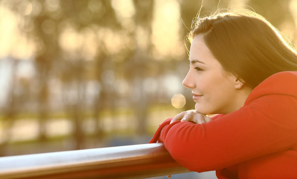 person-in-red-jumper-chin-resting-on-their-hand