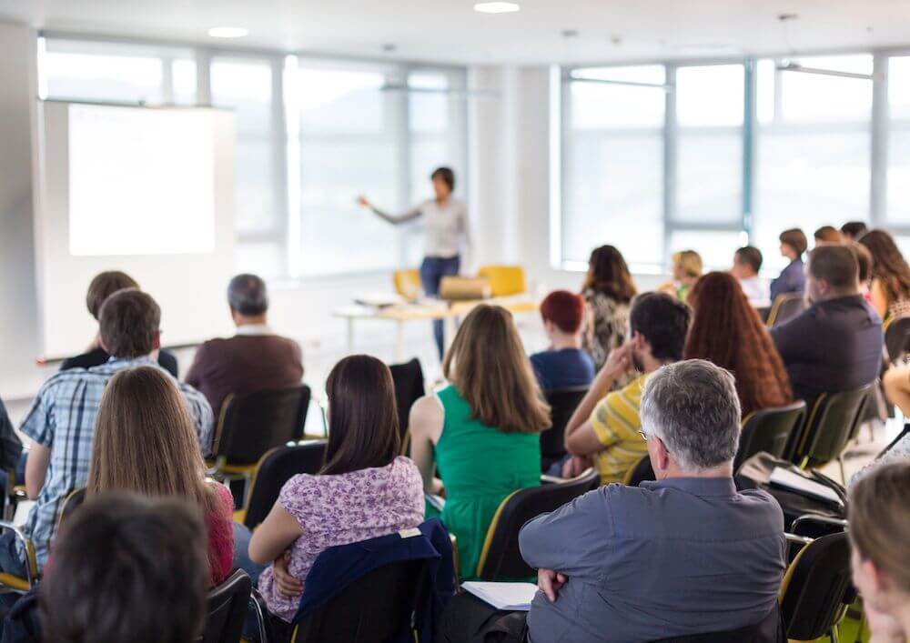 classroom-with-a-presenter-near-a-white-screen