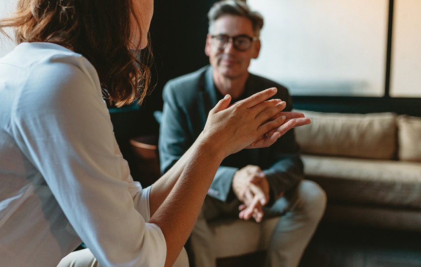 two-people-engaged-in-a-conversation-while-gesturing-with-their-hands