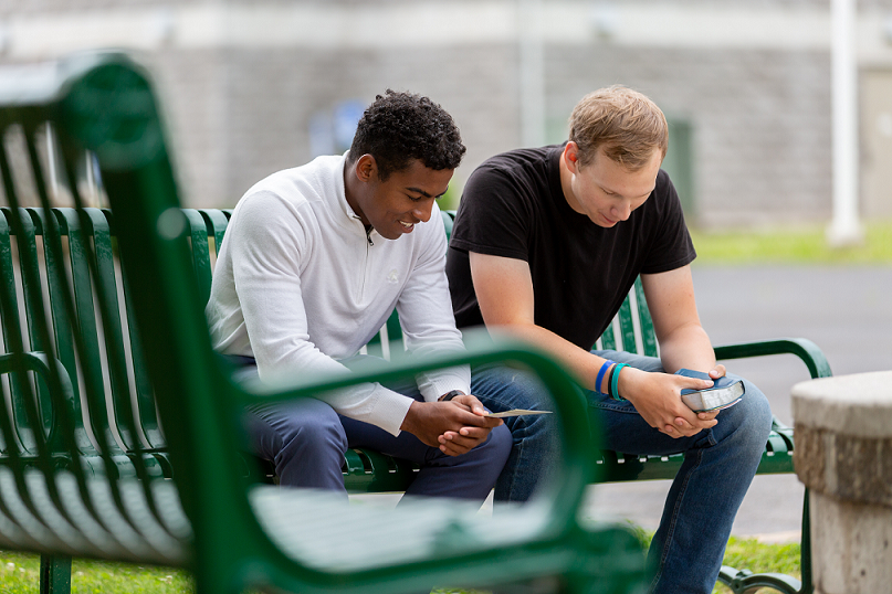 two-persons-siting-on-a-green-bench