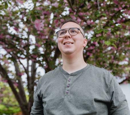 person-with-glasses-in-front-of-a-flowering-tree