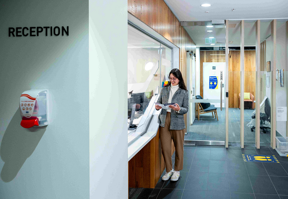Spectrum-reception-area-with-a-person-waiting-while-reading-publication Spectrum-reception-area-with-a-person-waiting-while-reading-publication