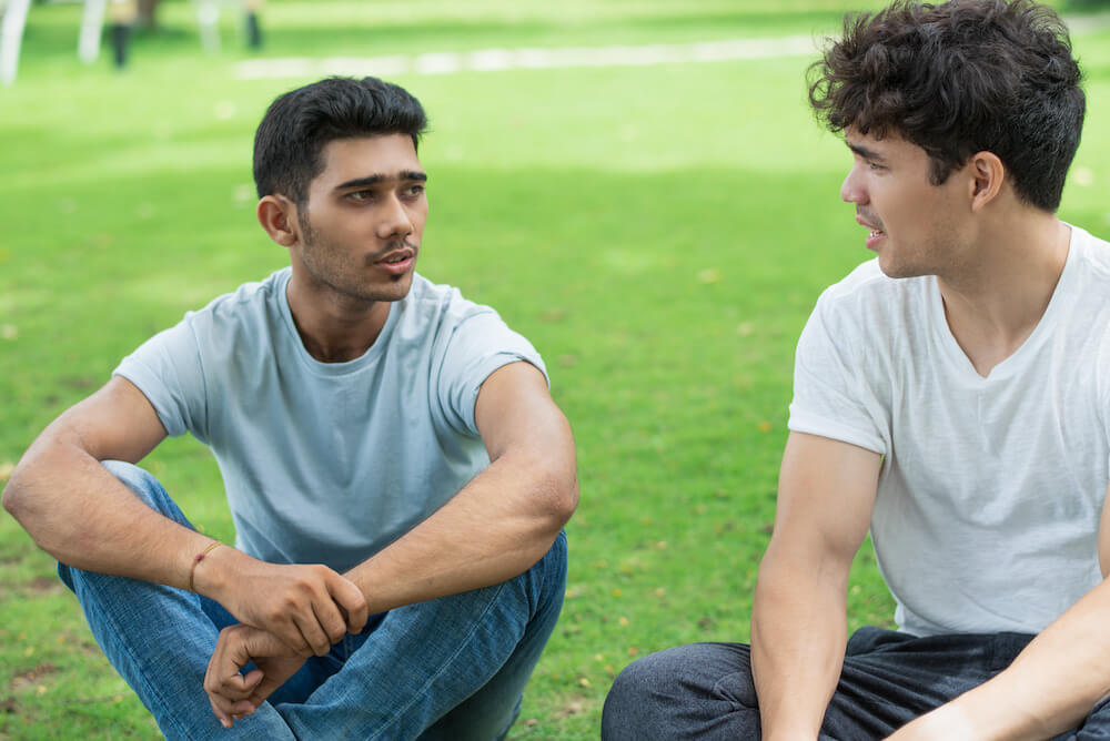 two-individuals-sitting-outdoors-on-a-grassy-area