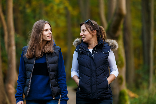 two-people-walking-side-by-side-in-a-wooded-area